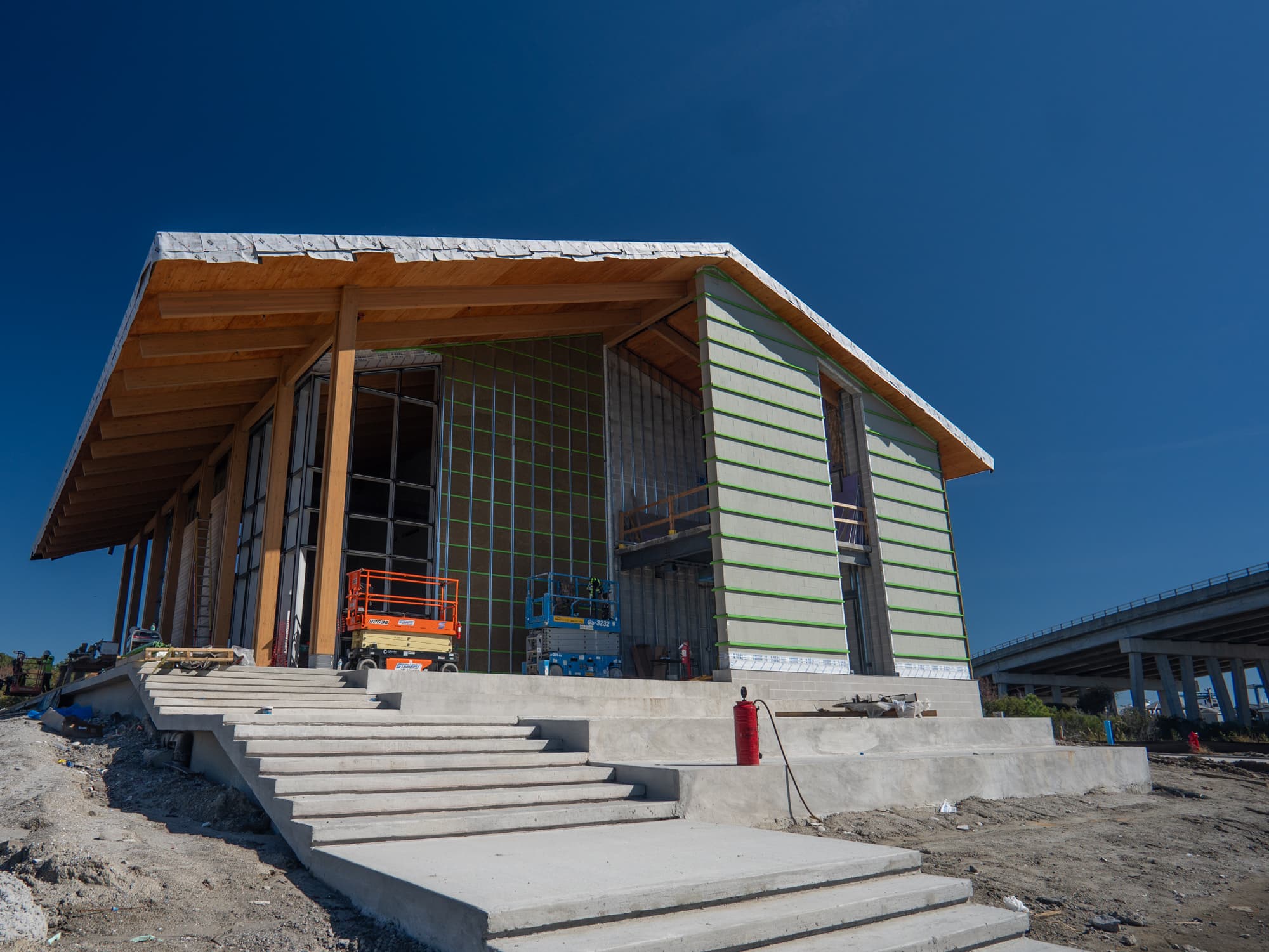 Coastal maritime center under construction with mass-timber roof and steel framing